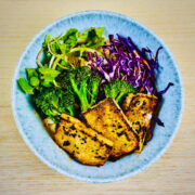 Vegan tantanmen ramen bowl with fried tofu steaks, broccolini, red cabbage and watercress