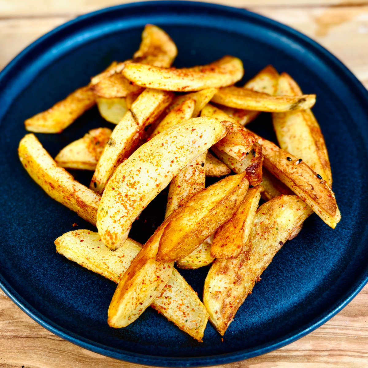 A plate of vegan Japanese togarashi fries. Golden, crunchy hand-cut potato fries made from scratch and seasoned with a cajun-like Japanese spice called shichimi togarashi.
