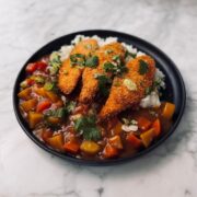 Sweet potato katsu curry with three golden panko-crusted cutlets over Japanese white rice garnished with coriander and spring onions