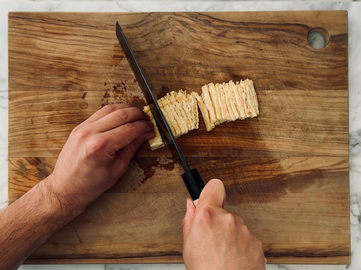 Thin matchstick-style slices of abura-age laid neatly on a cutting board.
Thin strips blend beautifully into the rice without overpowering any bite.