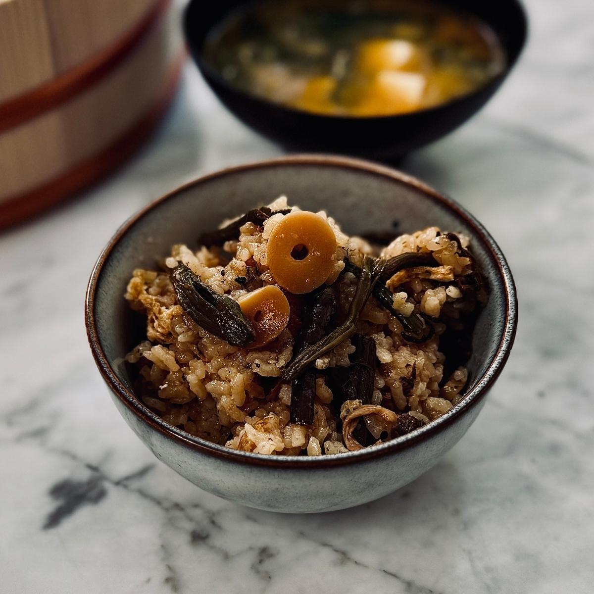 a bowl of mountain vegetable rice (sansai gohan) served next to a bowl of miso soup

