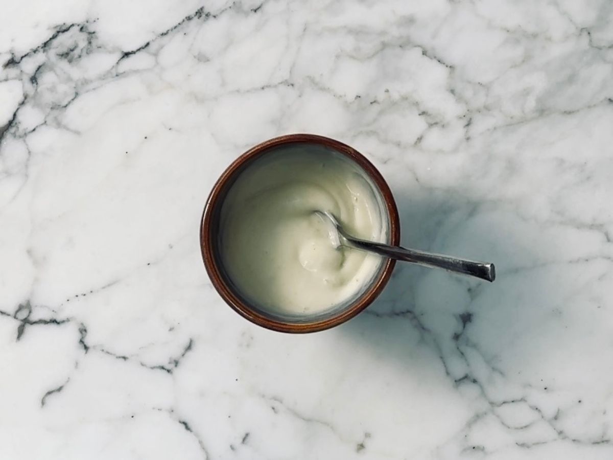 Wasabi mayo in a small bowl with a teaspoon in it.