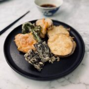 Plate of crispy vegan vegetable tempura with a bowl of soy dipping sauce