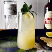 Yuzu mule cocktail in a tall glass garnished with mint and lime