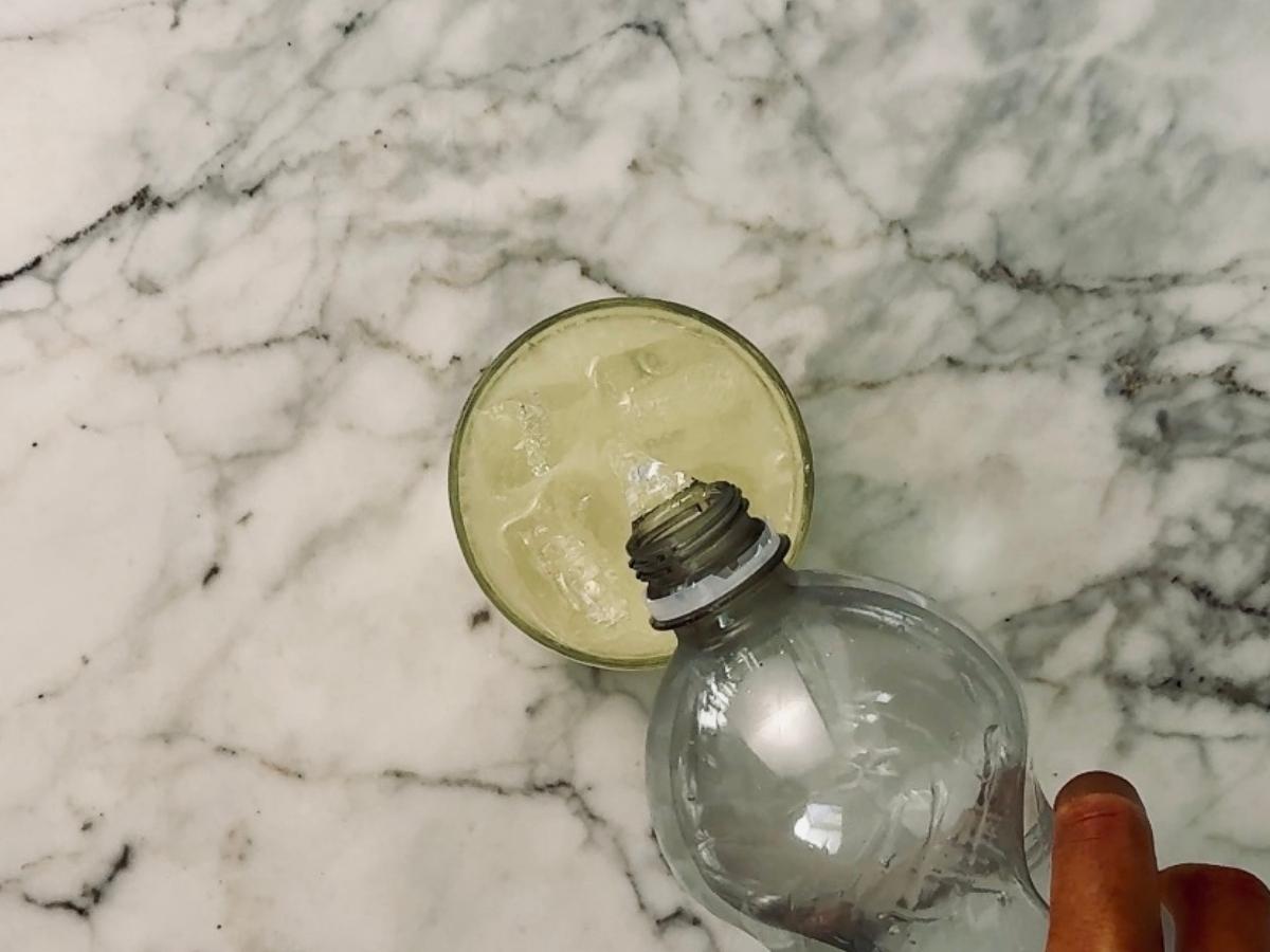 Soda water being gently poured into the glass, forming a light fizzy top layer.