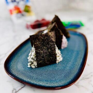 3 onigiri on a rectangular plate with rounded edges