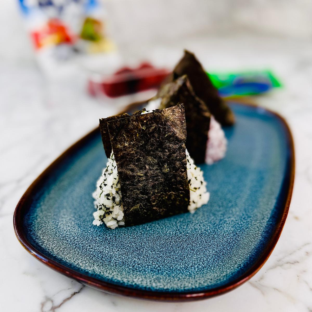 3 onigiri on a rectangular plate with rounded edges