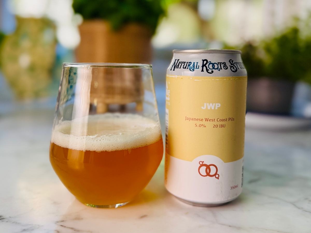 Can of Natural Roots West Coast Pils with a glass of clear pale beer and a white head