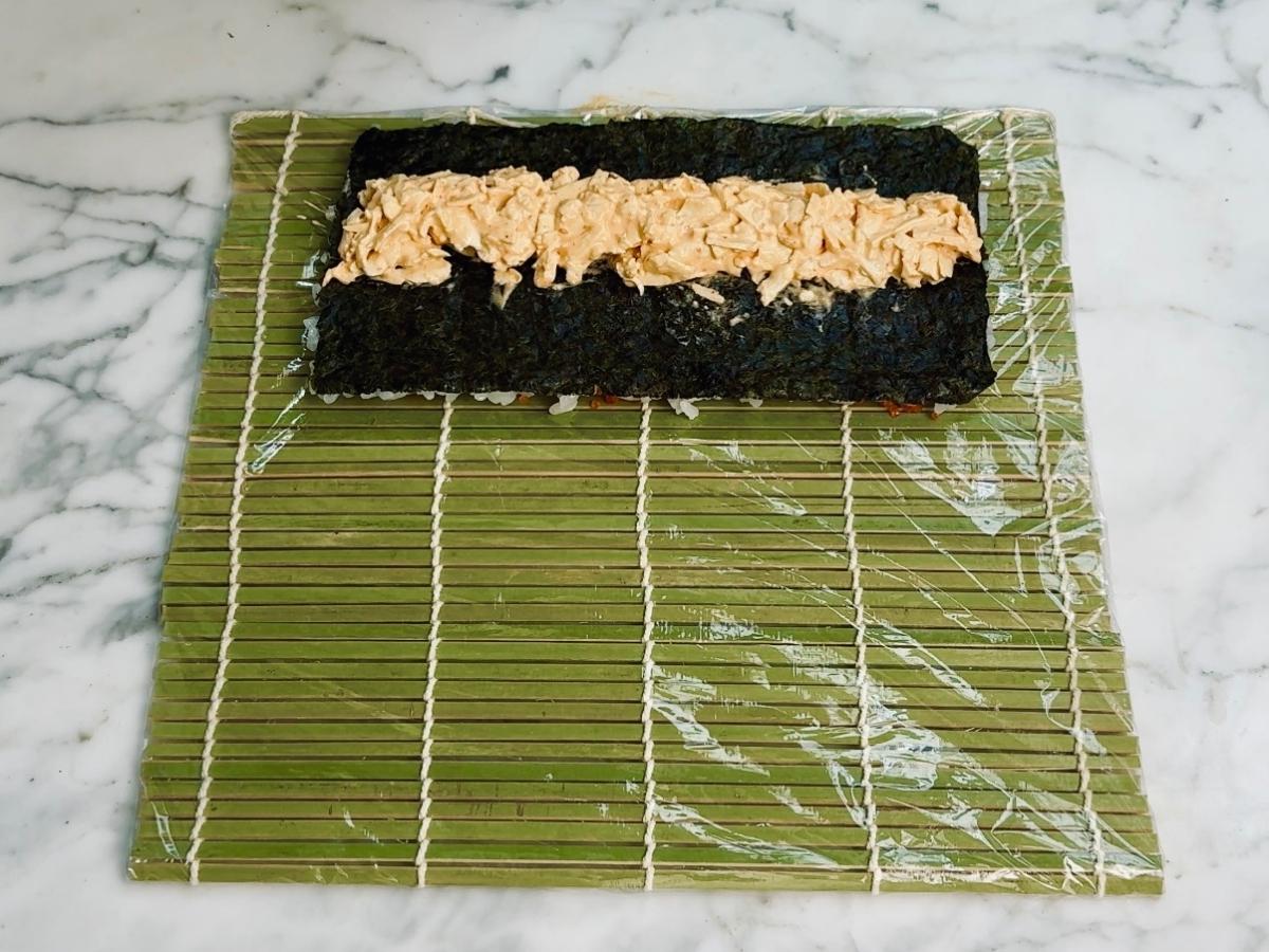 Tofu crab mixture spread in a clean line across the middle of the nori sheet.