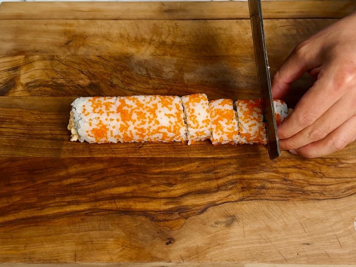 Clean sushi slices on a cutting board showing colorful layers inside.