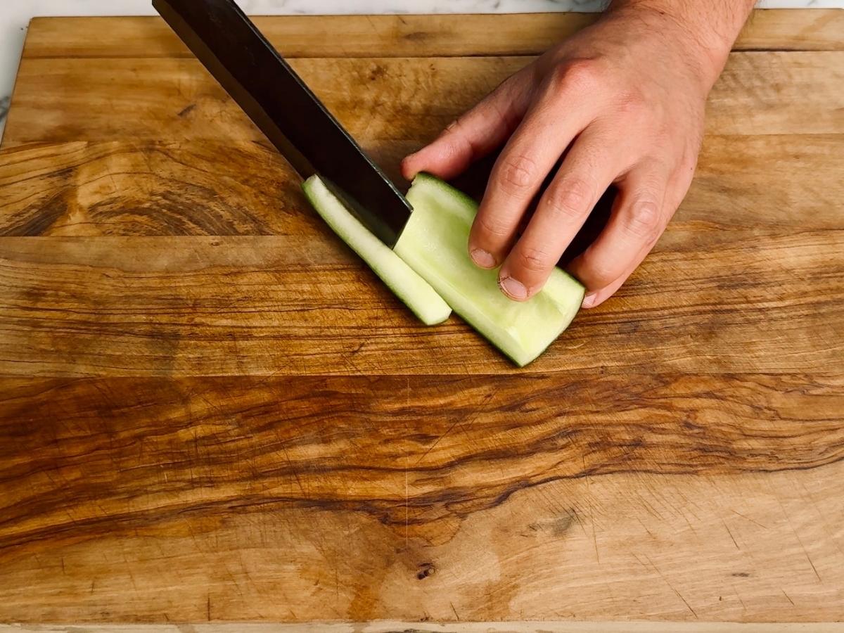 Cucumber being cut into sticks.