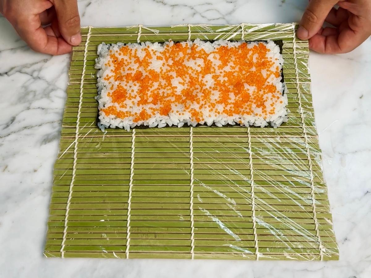 Bright orange vegan caviar scattered over the sushi rice.