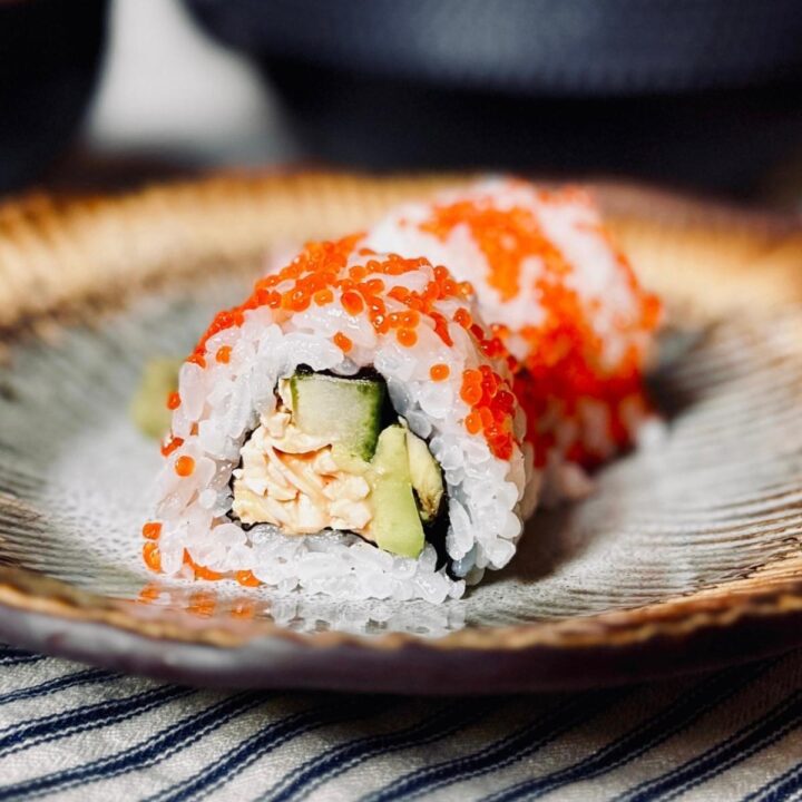 2 pieces of vegan california sushi on a ceramic plate
