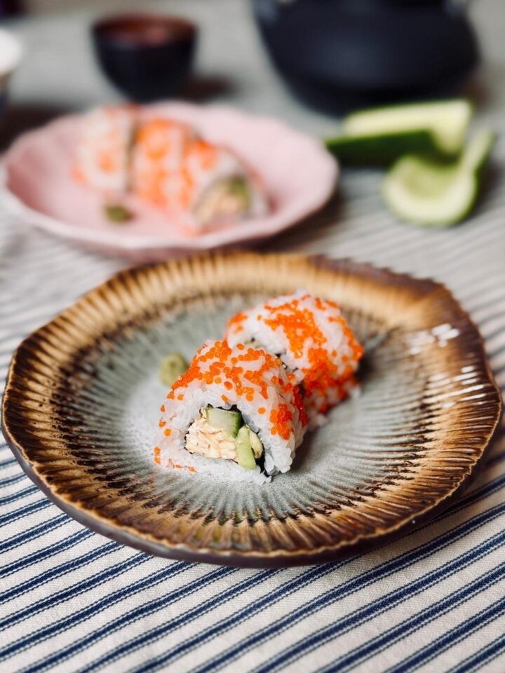 2 plates of vegan california roll pieces. Each served with a small dollop of wasabi paste