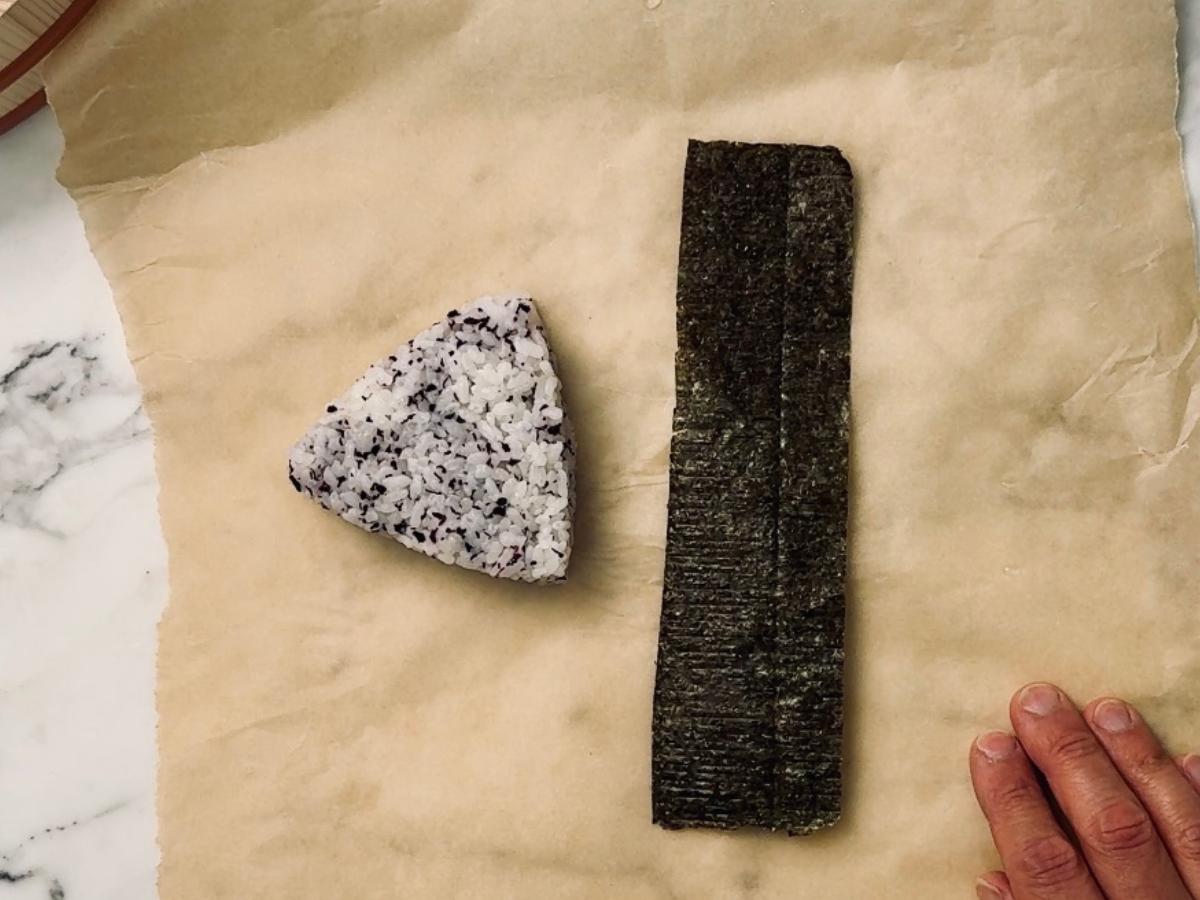triangular ongiri released from mold next to a strip of nori