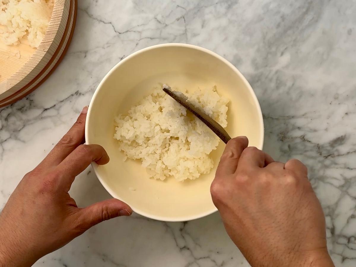 Mixing rice and salt in a bowl.