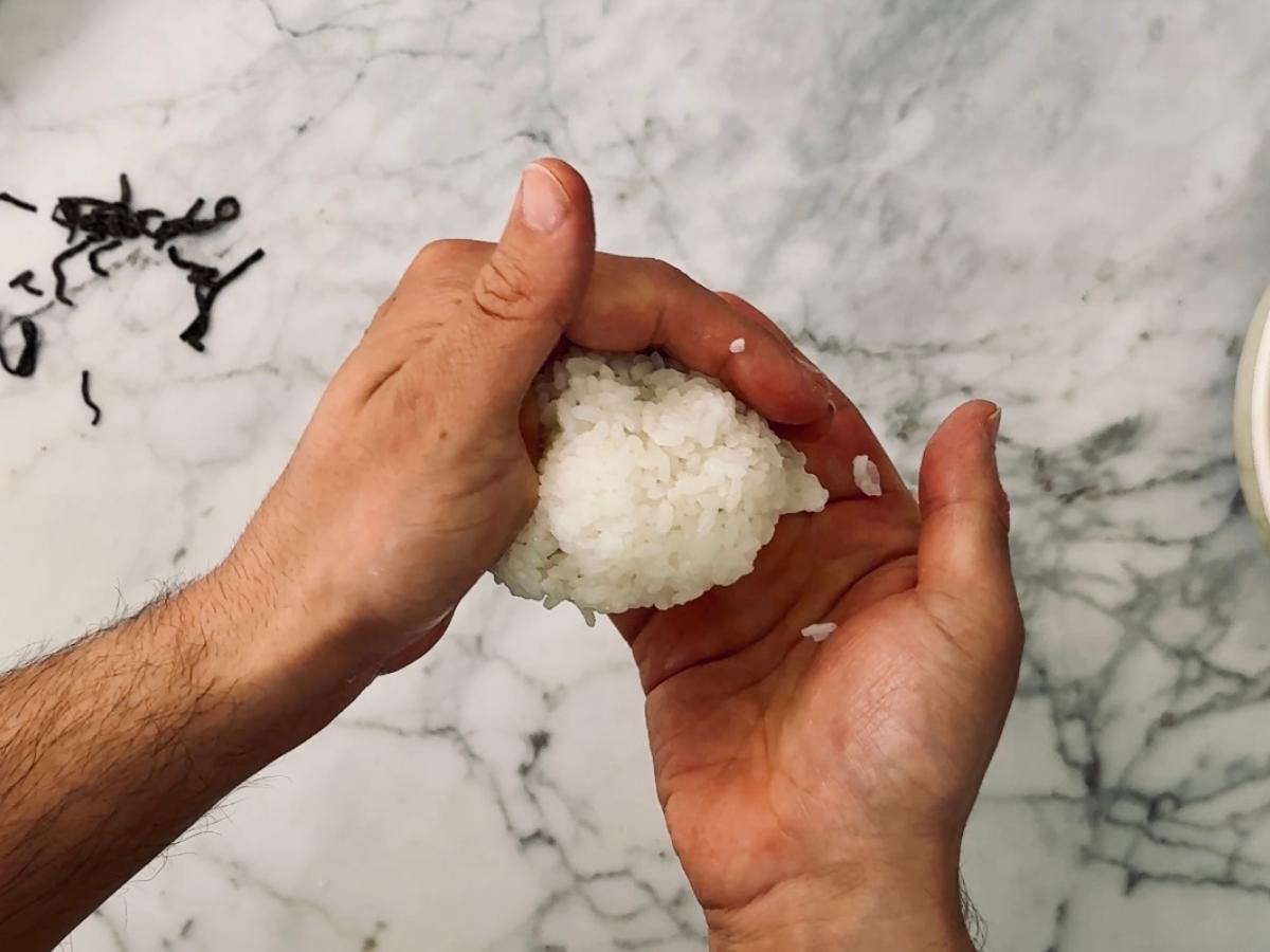 Shaping onigiri vegan rice ball into an initial, rough ball shape