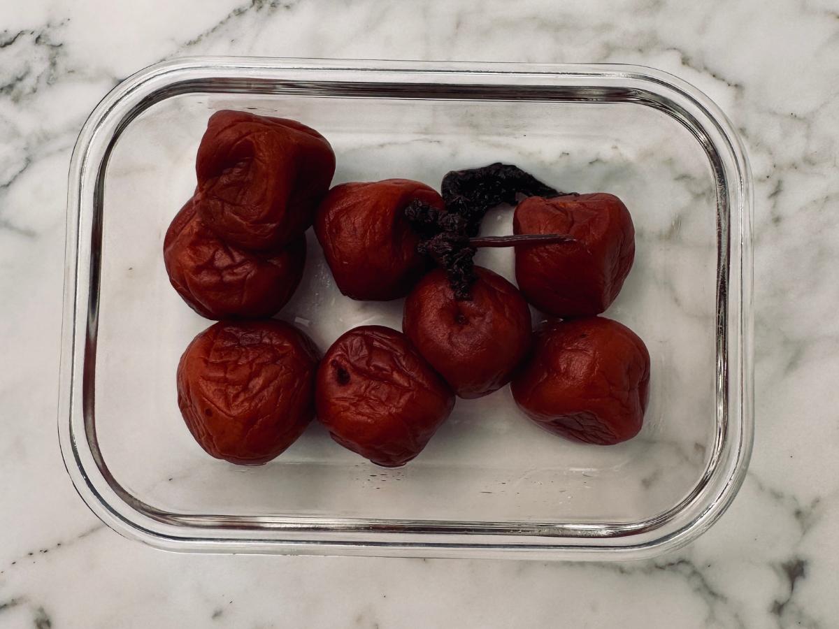 some pickled plums in a square glass dish