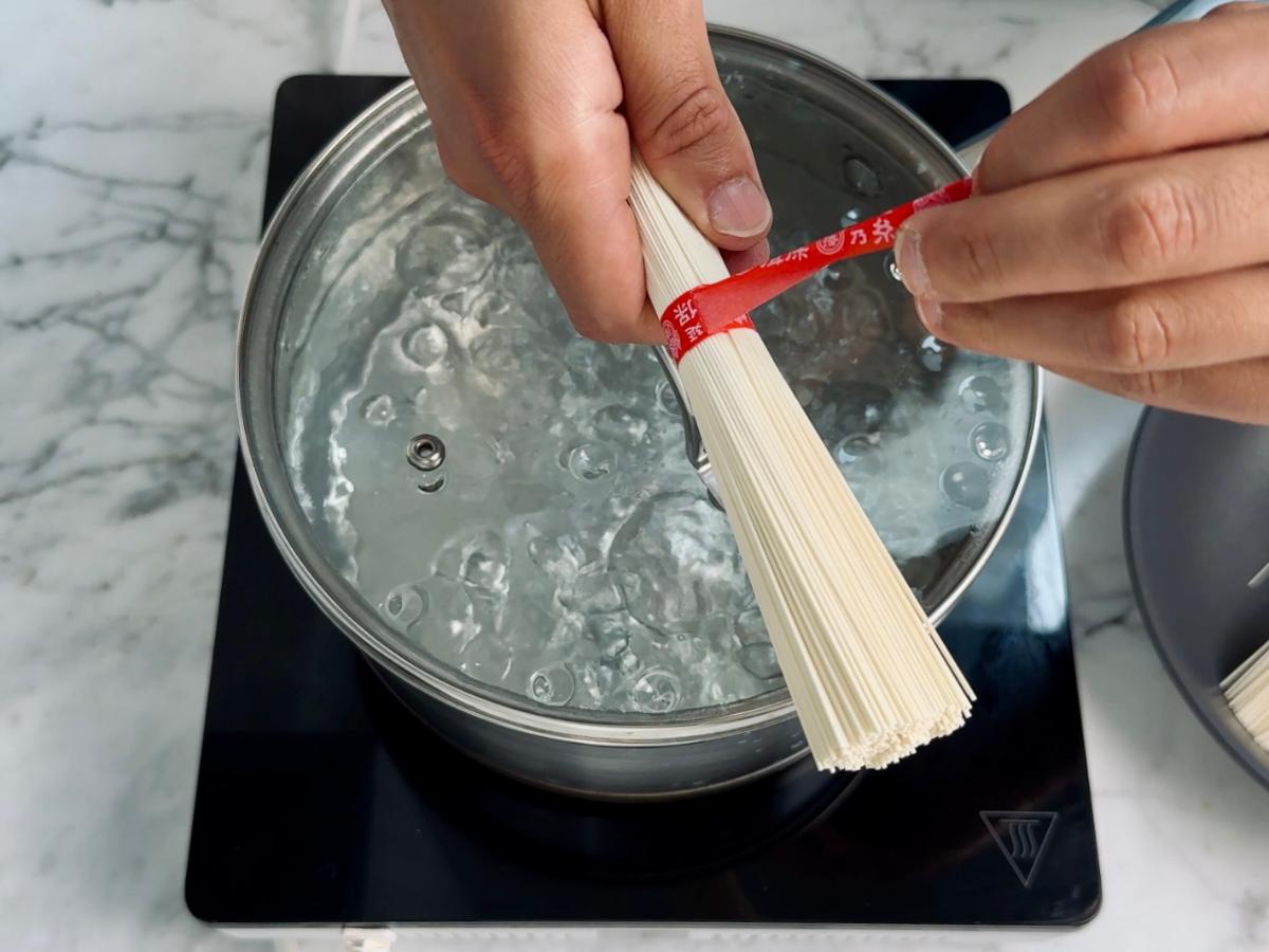 Somen bundles being gently separated by hand before cooking.
