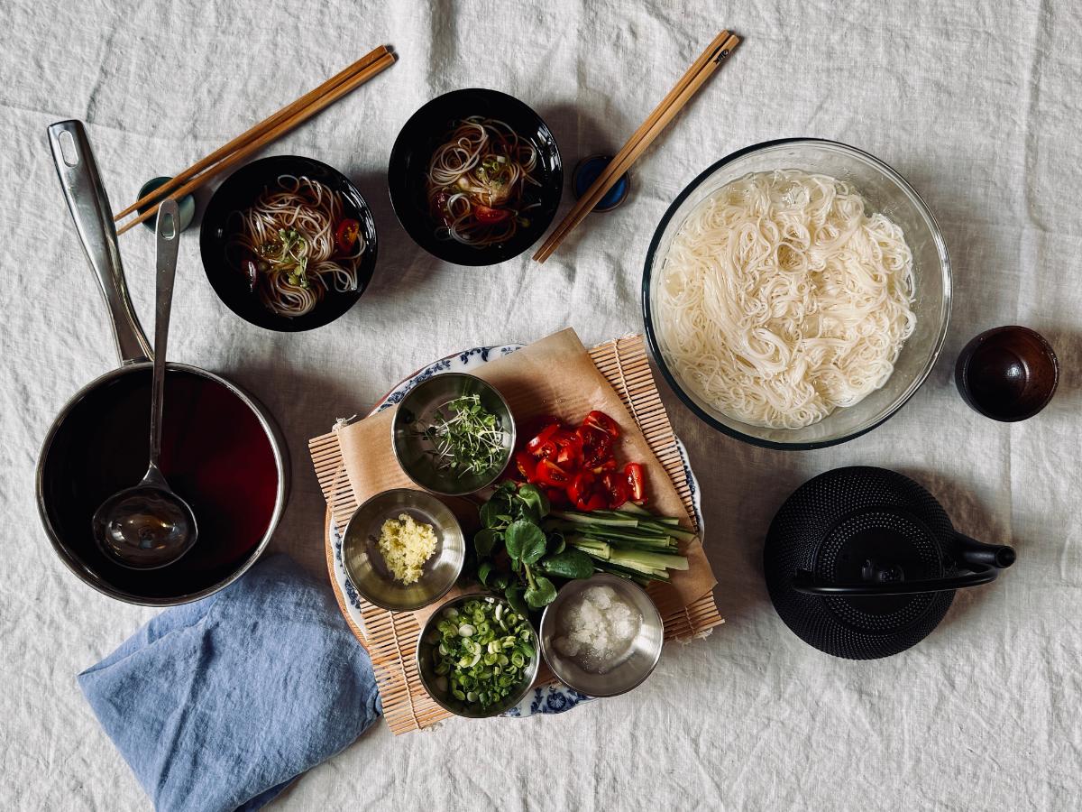 Table set with dipping bowls, chopsticks, and toppings