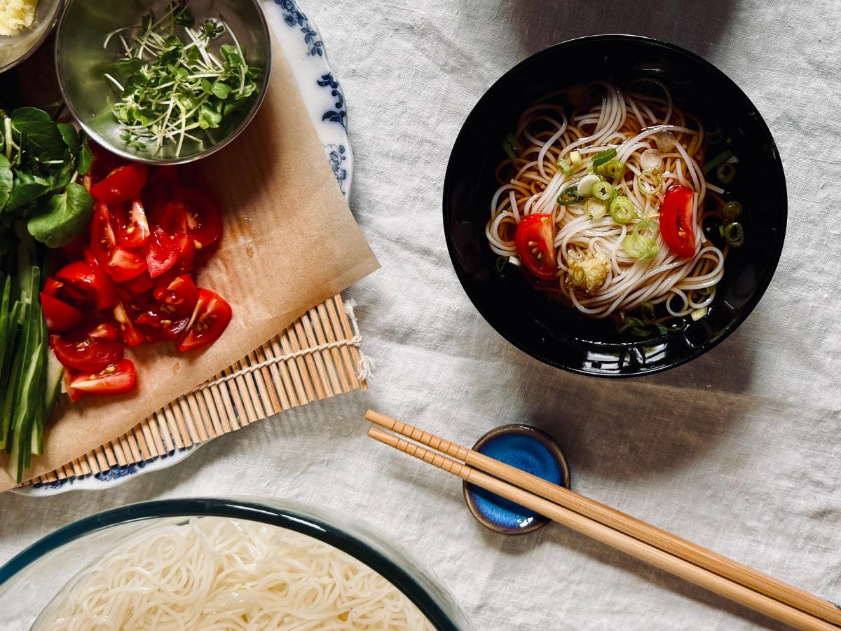 A small bundle of noodles in sauce with toppings sprinkled on top.
