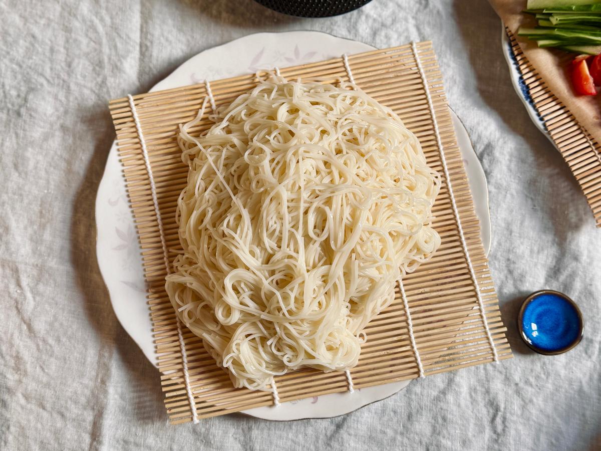 Drained somen noodles placed on a bamboo mat ready to serve.