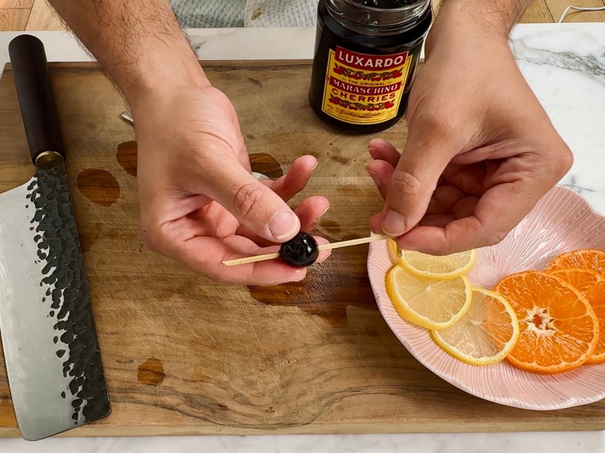 Spear the maraschino cherry on a cocktail stick and set aside.
