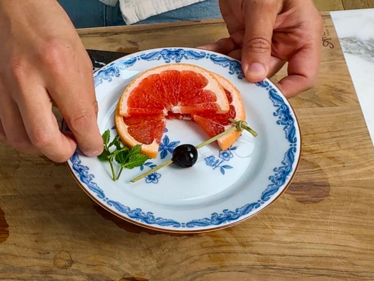 Fresh green mint sprigs laid out next to a grapefruit slice and cherry garnish.


