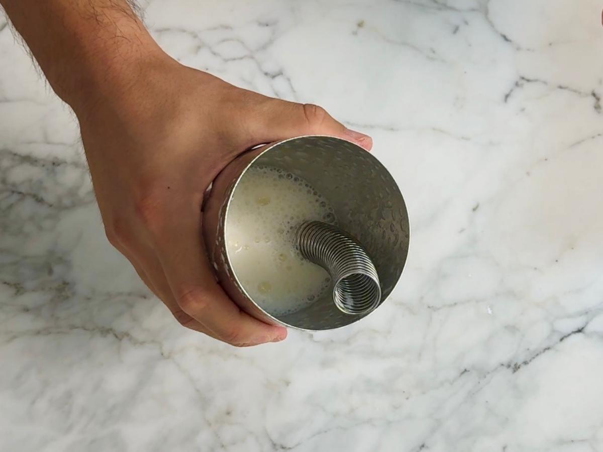 A dry shaken foamy liquid inside a shaker.