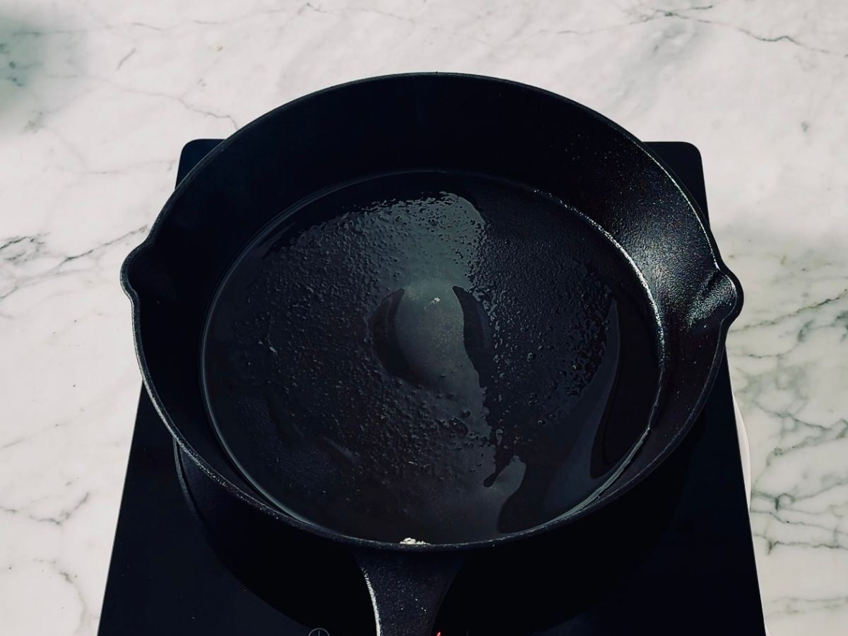Hot frying pan with sesame oil for frying boy choy (pak choi)