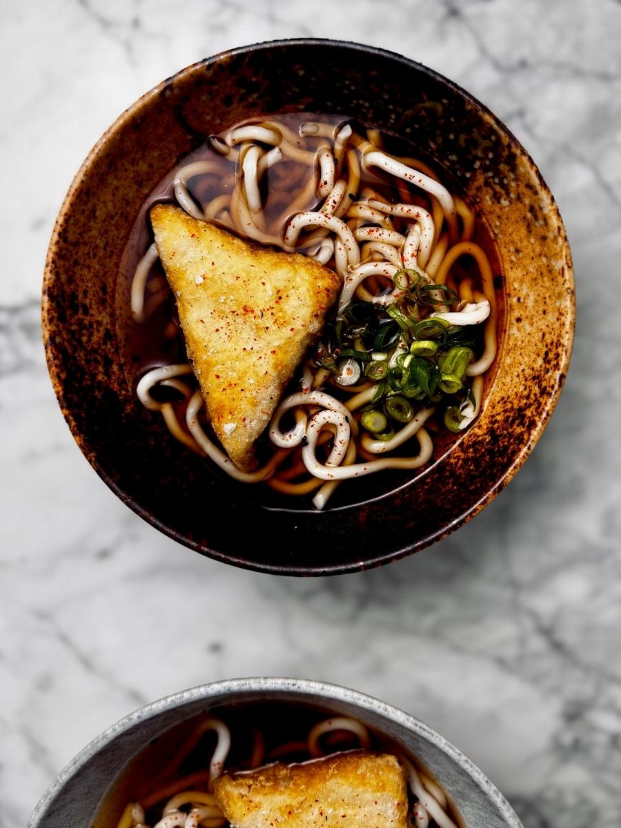 a bowl of vegan kake udon, garnished