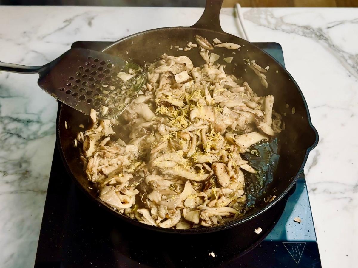Mushroom miso sauce cooking in a skillet with soy sauce, mirin, lemon zest, and chilli flakes.
