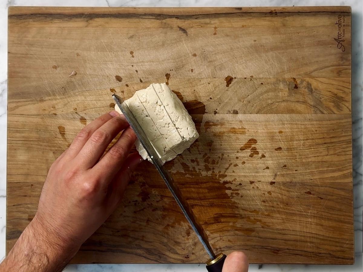 tofu being cut into 1 inch slabs