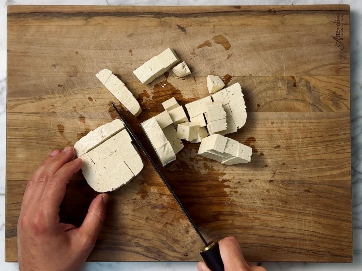 tofu being cubed into 1 inch cubes