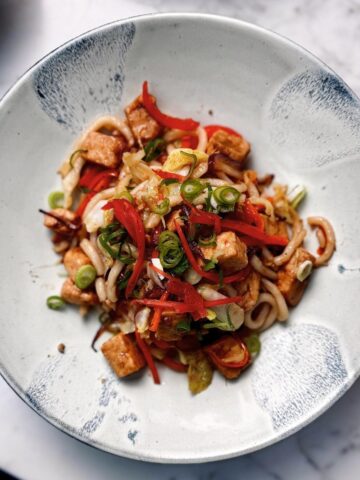 yaki udon noodles garnished with pickled ginger and spring onions