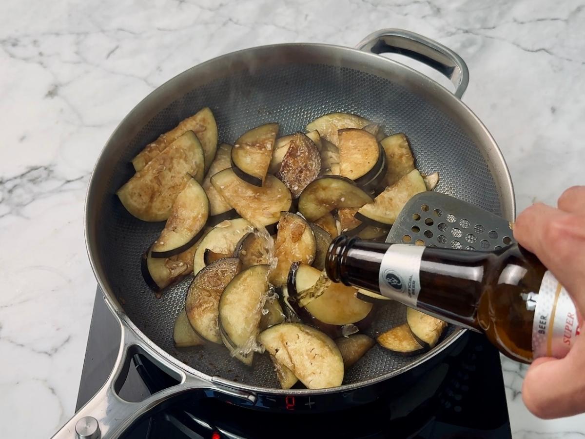Beer being added to the frying pan