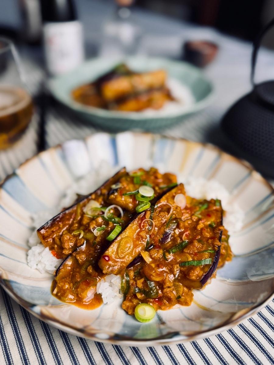 mapo eggplant on a bed of white rice garnished with spring onions