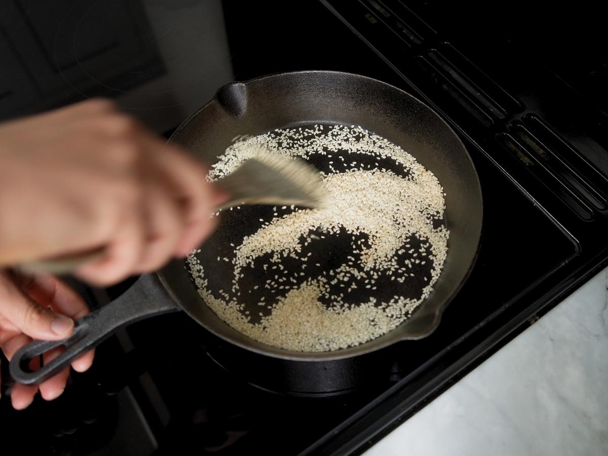 sesame seeds being toasted in a skillet
