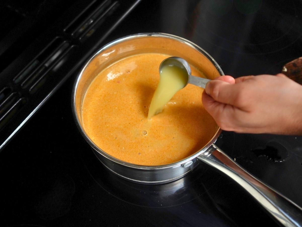 yuzu juice being added to the broth as it simmers away on the hob