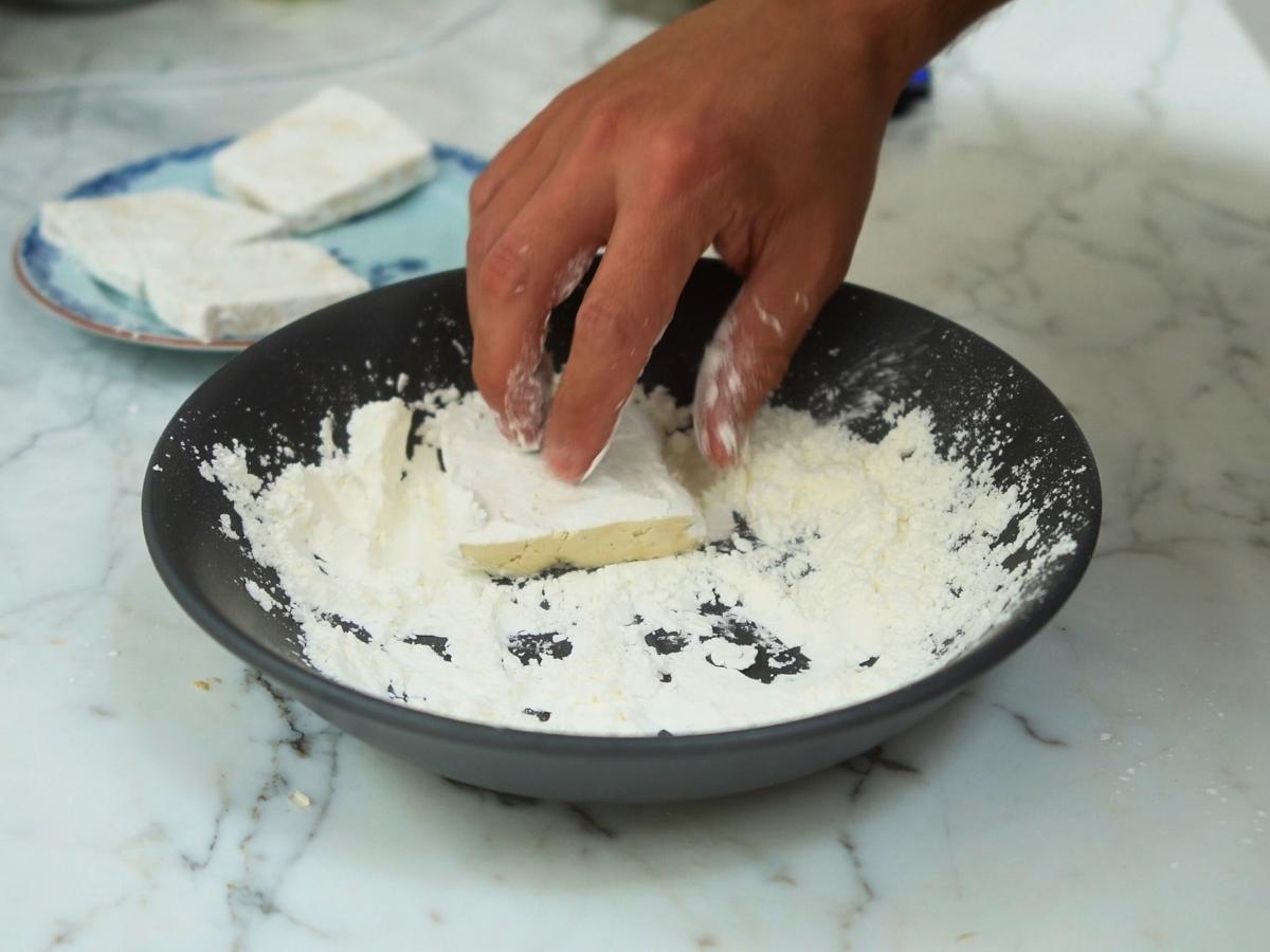 sliced tofu being coated in cornstarch

