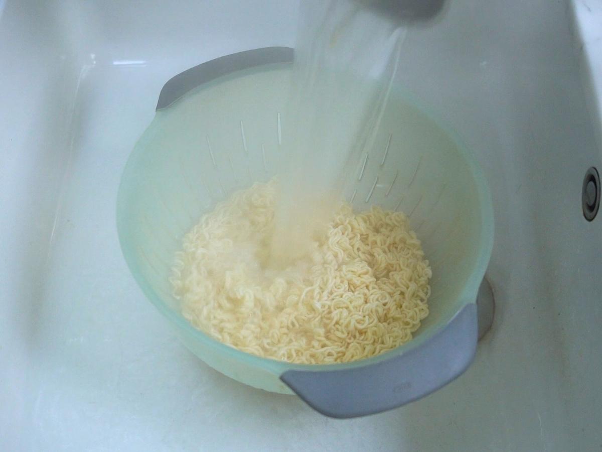noodles being drained into a colander