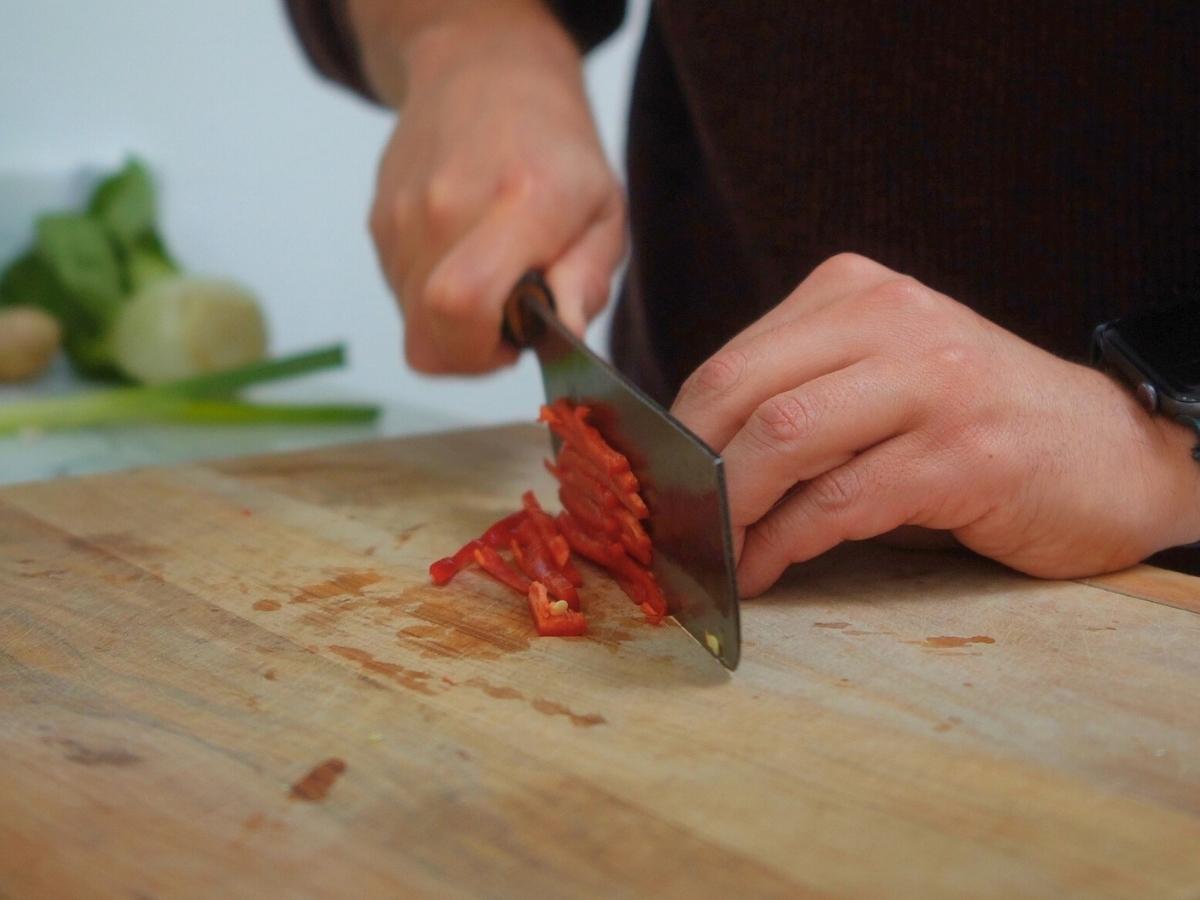 red chili being sliced lengthways into thin slices