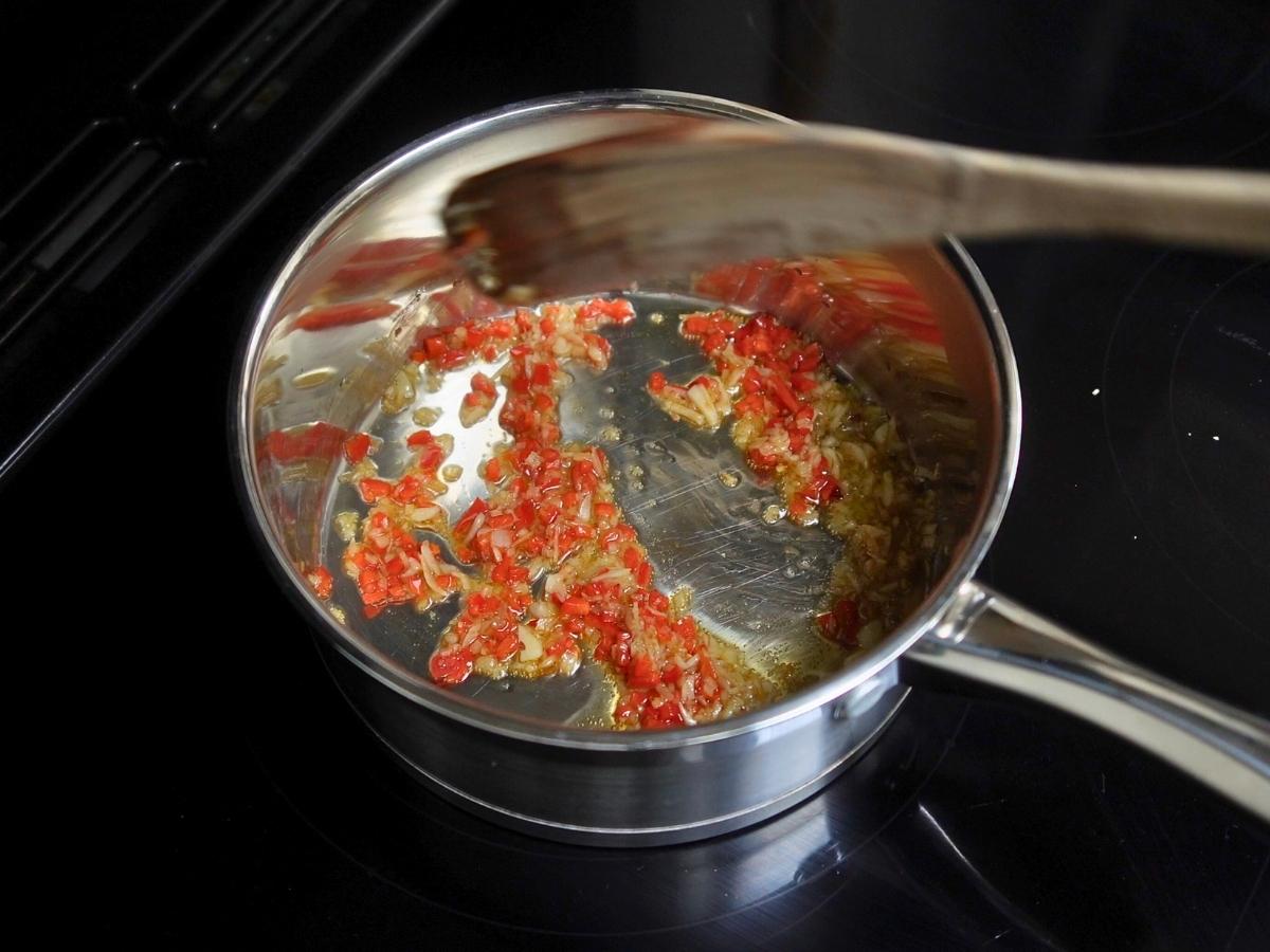 chili, garlic, ginger being sautéd in a pan
