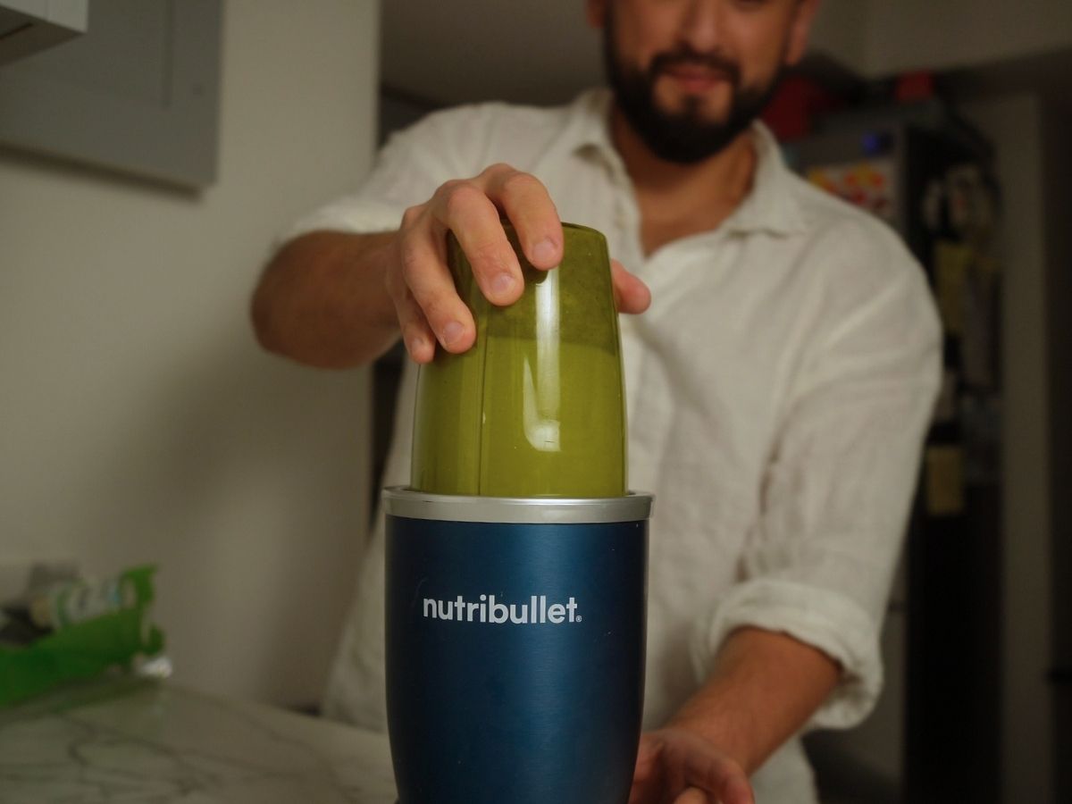 Pesto ingredients being blended in a blender
