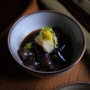 Eggplant agebitashi on a wooden tray garnished with grated daikon, spring onions and ginger