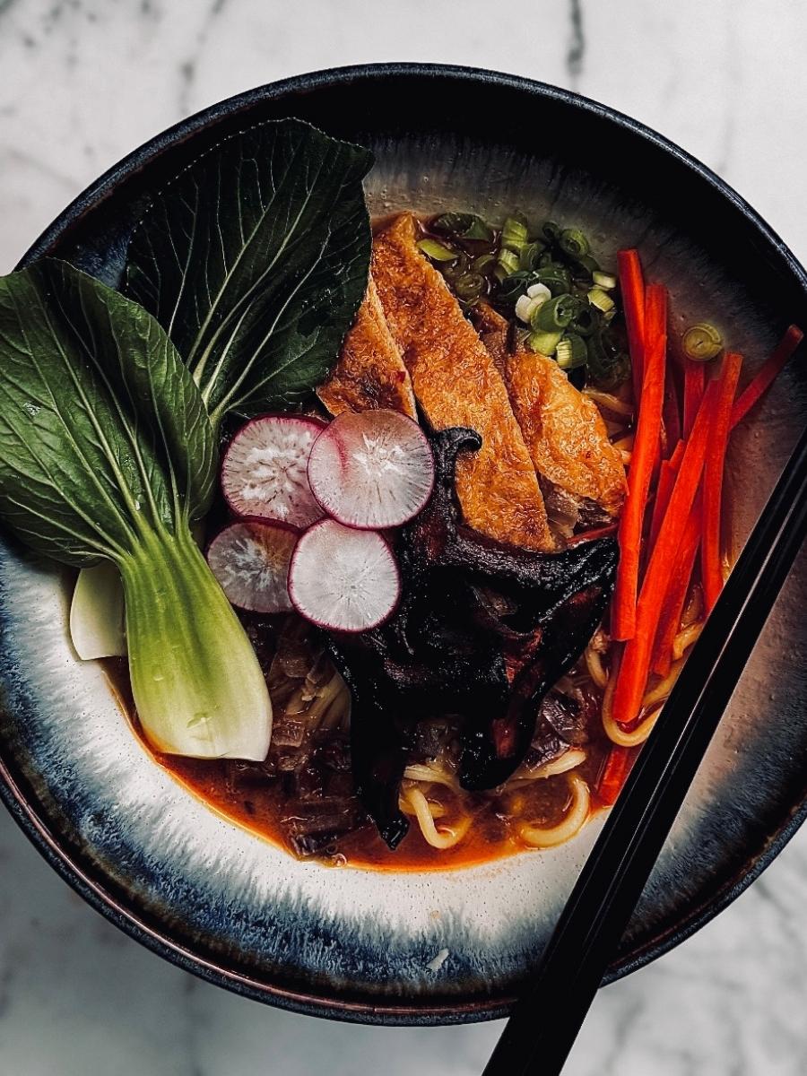 close up of spicy ramen noodles with toppings